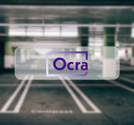 Ocra logo on top of image of empty parking spaces in parking lot